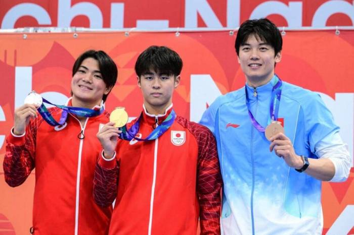 Yumeki Kojima (giữa) chụp ảnh cùng HC vàng 400 m hỗn hợp cá nhân tại ASIAD 2026, bên cạnh đồng đội Tomoyuki Matsushita (trái) và kình ngư Trung Quốc Wang Shun, tại Trung tâm Thể thao dưới nước Tokyo, Nhật Bản ngày 22/9/2026. Ảnh: AFP