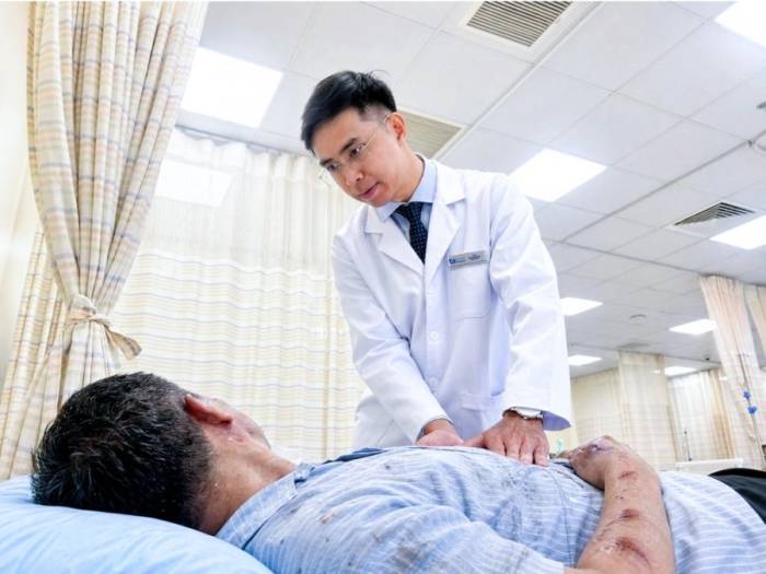Bác sĩ Đạt đánh giá tình trạng chấn thương của anh Xiếu. Ảnh: Phòng khám Đa khoa Tâm Anh Quận 7