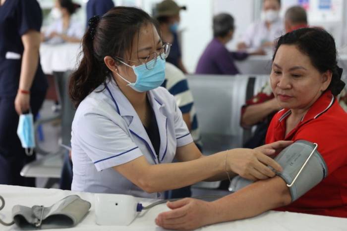Bác sĩ đo huyết áp cho một người dân. Ảnh: Quỳnh Trần
