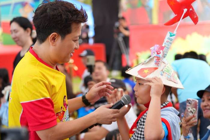 Gia Huy giao lưu cùng nghệ sĩ Trường Giang khi nán lại sân khấu chơi thêm sau khi hoàn thành đường chạy. Ảnh: VM