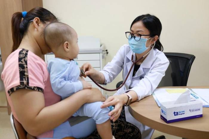 Bác sĩ Bội Hy khám cho trẻ mắc tay chân miệng tại Bệnh viện Đa khoa Tâm Anh Quận 8. Ảnh: Nguyệt Nhi