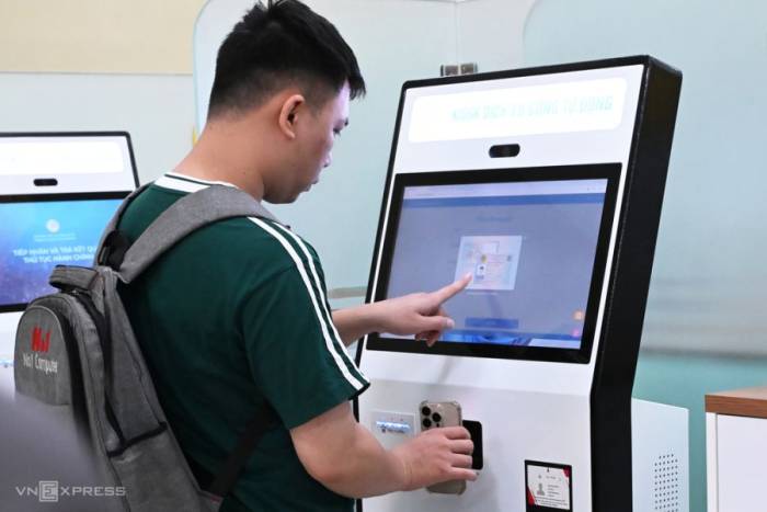 Người dân tương tác với kiosk dịch vụ công tự động, tại bộ phận một cửa của Bộ Khoa học và Công nghệ. Ảnh: Trọng Đạt