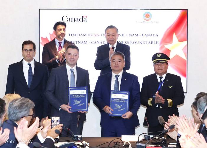 Đại diện Vietnam Airlines và CAE trao biên bản ghi nhớ hợp tác. Ảnh: TTXVN