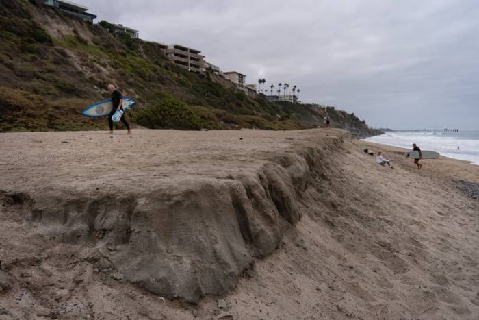 Những người lướt ván đi dọc theo bãi biển North Beach ở San Clemente, California, ngày 18/9. Ảnh: AP
