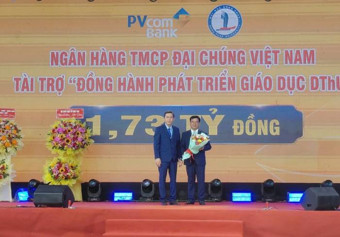 Tiến sĩ Trương Tấn Đạt, Hiệu trưởng Trường Đại học Đồng Tháp (trái) tặng hoa cho nhà tài trợ. Ảnh: Ngọc Tài