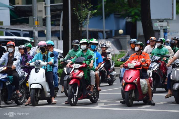 Tài xế các hãng xe công nghệ dừng chờ đèn giao thông ở trung tâm TP HCM. Ảnh: Thanh Tùng