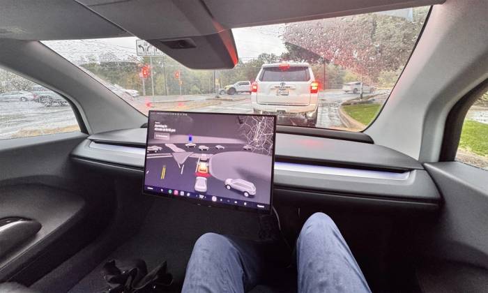 Một chiếc robotaxi của Tesla chở khách vào ngày trời mưa. Ảnh: Ron Benfield