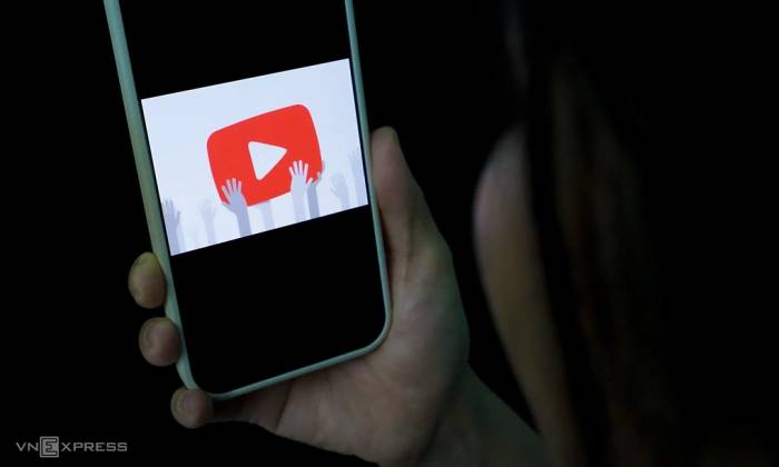 Một người sử dụng smartphone với logo YouTube. Ảnh: Bảo Lâm