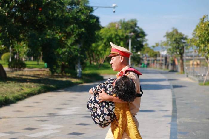 Cảnh sát giao thông hỗ trợ đưa người phụ nữ đi cấp cứu. Ảnh: Hồng Nhung
