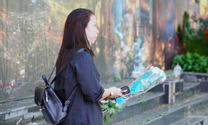 Người dân mang hoa trắng đến viếng liệt sĩ tại Công viên Lê Thị Riêng, trưa 13/10. Ảnh: Ngọc Ngân