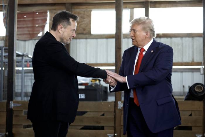 Ông Donald Trump (phải) bắt tay Elon Musk trong một sự kiện vận động tranh cử ở Butler, Pennsylvania, hồi tháng 10/2024. Ảnh: AFP