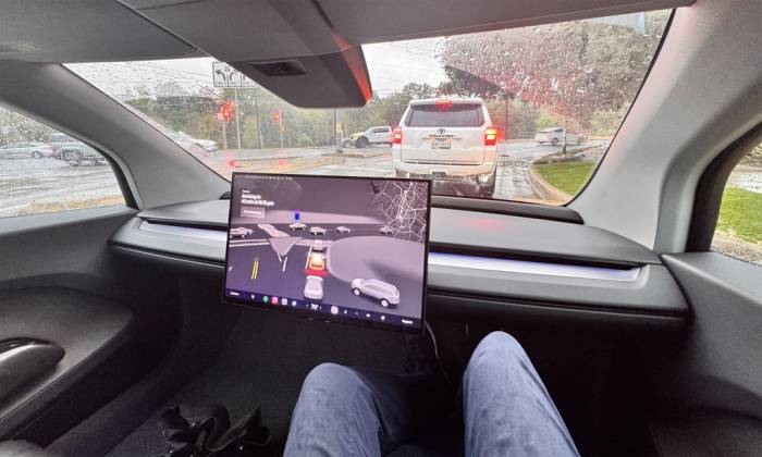 Một chiếc robotaxi của Tesla chở khách vào ngày trời mưa. Ảnh: Ron Benfield