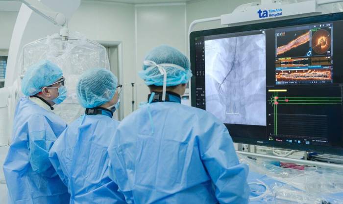Bác sĩ đặt stent tái thông dòng máu nuôi tim cho bệnh nhân với sự hỗ trợ của kỹ thuật chụp cắt lớp kết quang nội mạch (OCT). Ảnh: Bệnh viện Đa khoa Tâm Anh