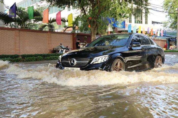 Nước từ sông Đồng Nai tràn qua bờ kè gây ngập đường Phan Văn Trị chiều 10/10. Ảnh: Phước Tuấn