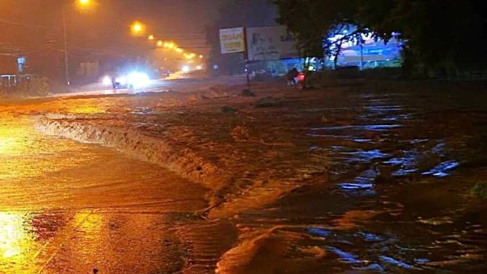 Nước lũ kéo cát đỏ tràn xuống đường Nguyễn Thông, tối 6/10. Ảnh: Phú Hài