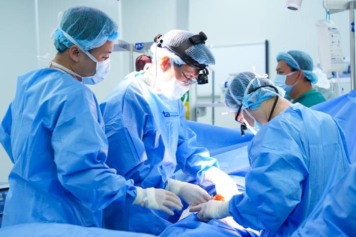 Phó giáo sư Vĩnh (giữa) và êkíp Trung tâm Ngoại Lồng ngực - Mạch máu phẫu thuật khâu vết thủng ở phổi cho người bệnh. Ảnh: Bệnh viện Đa khoa Tâm Anh
