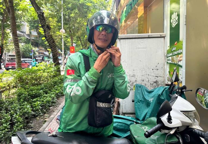 Tài xế GrabBike luôn đeo kính màu sau khi bị mất một mắt trái sau sự cố khi chạy xe. Ảnh: Lê Tuyết