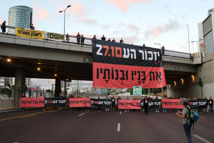 Người dân Israel giương cao biểu ngữ Hãy nhớ và đừng bao giờ quên khi chặn đường cao tốc để dành một phút mặc niệm trong buổi lễ tưởng niệm ở Tel Aviv ngày 7/10. Ảnh: AFP