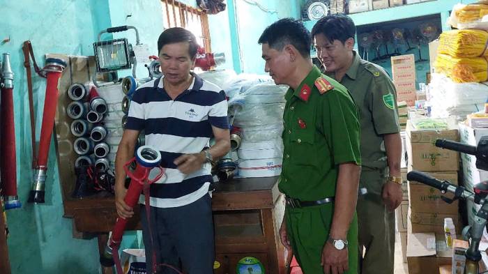 Ông Hai Nùng (trái) kiểm tra thiết bị chữa cháy được ông đầu tư nhiều năm qua. Ảnh: Thanh Thảo