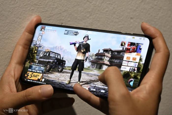Một người chơi game bắn súng trên điện thoại di động. Ảnh: Trọng Đạt, Nguyễn Thanh