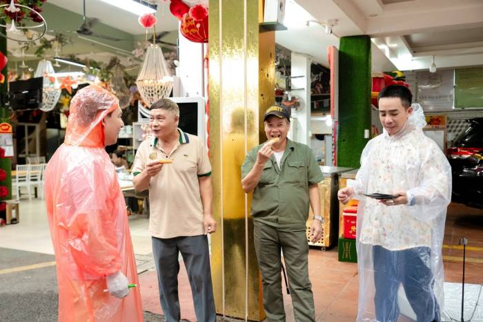 Nghệ sĩ Quang Thắng, Đỗ Duy Nam mời người dân bánh mì que. Ảnh: BTC