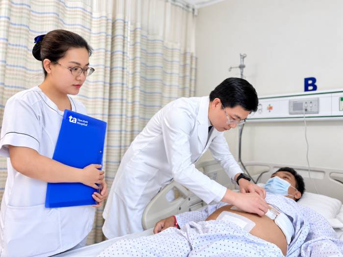 Bác sĩ Khánh đang kiểm tra vết mổ cho ông Trọng sau ca phẫu thuật. Ảnh: Bệnh viện Đa khoa Tâm Anh