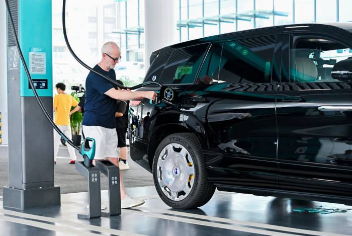 Một khách hàng đang sạc xe điện tại trạm sạc nhanh của BYD. Ảnh: Car Magazine