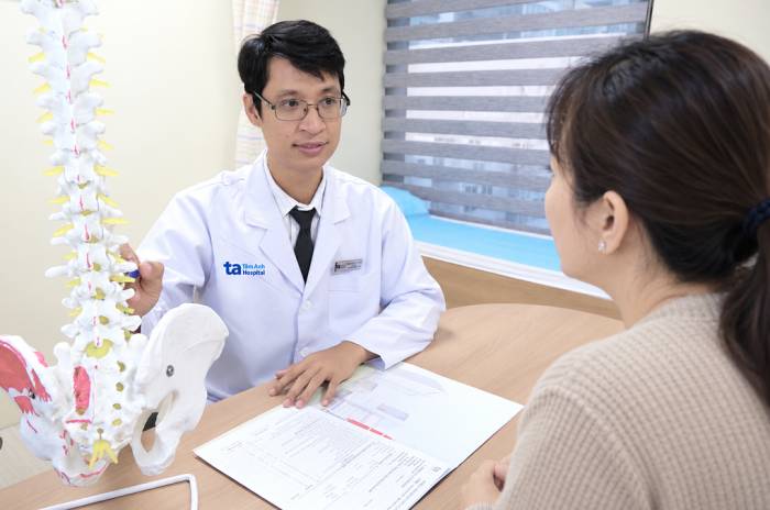 Bác sĩ Duận giải thích tình trạng đĩa đệm cho người nhà của Nam. Ảnh: Bệnh viện Đa khoa Tâm Anh