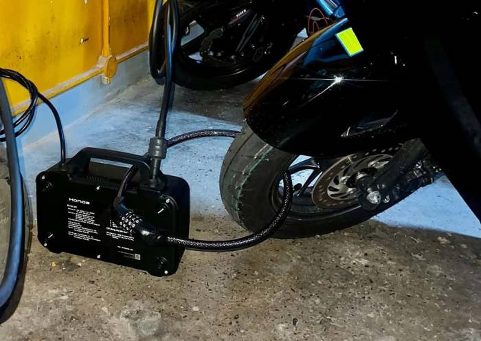 Bộ sạc bị xích vào bánh khi sạc xe máy điện. Ảnh: Hải Đăng