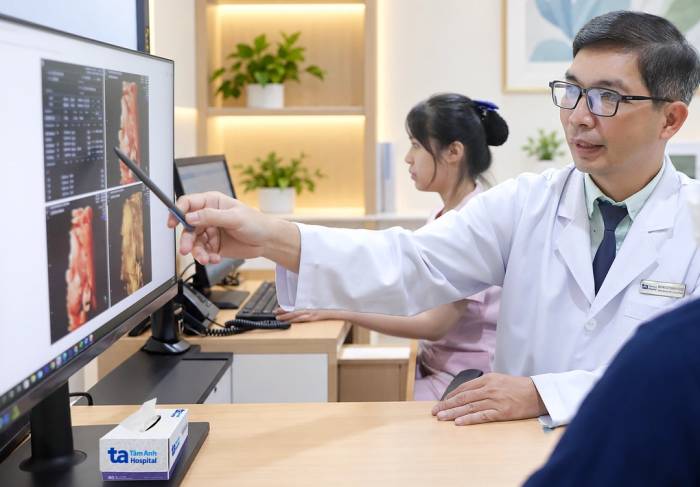 Bác sĩ Thanh Hùng giải thích cho chị Thúy nguy cơ khi mang thai ở tuổi 50. Ảnh: Bệnh viện Đa khoa Tâm Anh