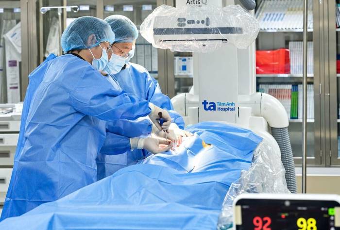 Bác sĩ Dũng (giữa) cùng êkíp lấy huyết khối và đặt stent tái thông mạch máu nuôi chân cho người bệnh. Ảnh: Bệnh viện Đa khoa Tâm Anh