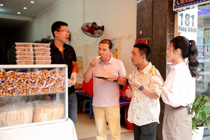 Nghệ sĩ Quang Thắng, Đỗ Duy Nam, Phí Linh (từ phải sang) thưởng thức món bánh mì que 3.000 một ổ. Ảnh: BTC