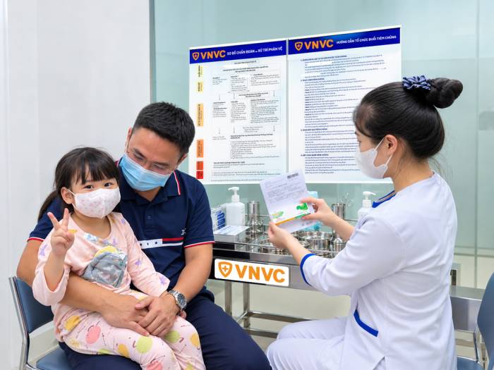 Vợ chồng chị Nay Ngân đưa con gái 3 tuổi từng mắc tay chân miệng tiêm vắc xin tại VNVC Ea Tam, Đắk Lắk. Ảnh: Bùi Huyền