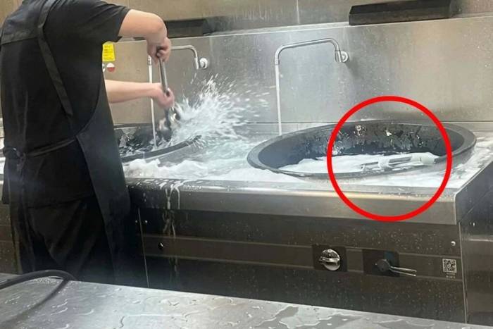 Cảnh nhân viên nhà bếp giặt đồ trong chậu rửa thực phẩm ở trường mầm non. Ảnh: Weibo