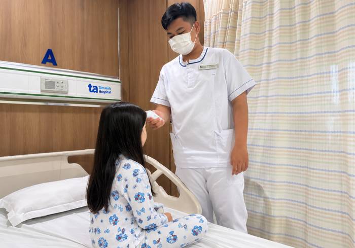 Điều dưỡng kiểm tra thân nhiệt cho Huệ. Ảnh: Bệnh viện Đa khoa Tâm Anh