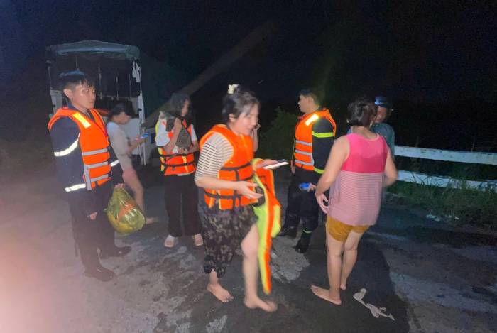 Công an TP HCM giải cứu 12 người ở công trình Suối Cái, phường Tân Khánh bị cô lập khi lũ về rạng sáng 6/10. Ảnh: Thái Hà