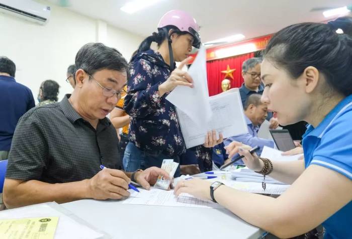 Cán bộ BHXH hỗ trợ người dân Hà Nội làm thủ tục liên quan hưu trí. Ảnh: Thu Hương