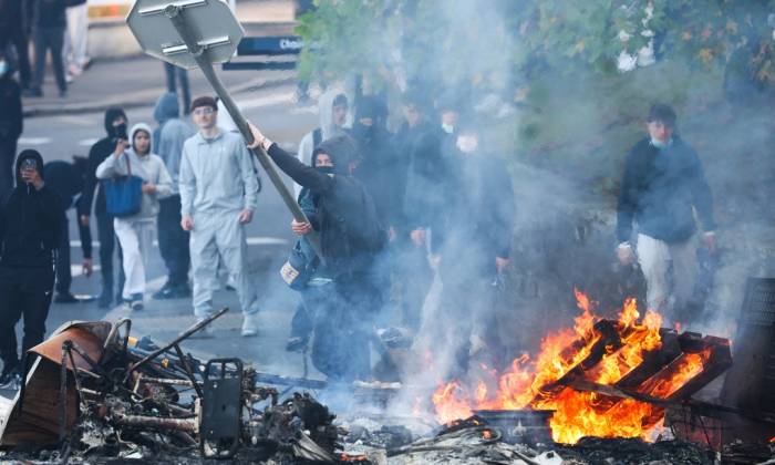 Người biểu tình ném biển báo giao thông vào đống lửa tại Brest, Pháp ngày 2/10. Ảnh: AFP