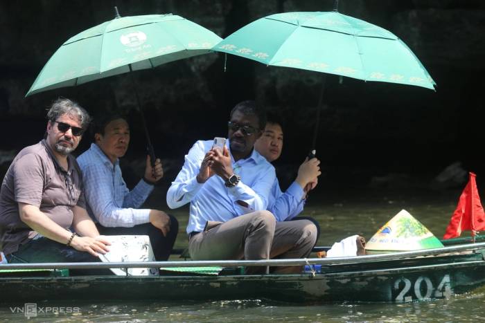 Giám đốc Trung tâm di sản thế giới Lazare Eloundou Assomo (người cầm điện thoại) tham quan Tràng An, Ninh Bình sáng 1/10. Ảnh: Gia Chính