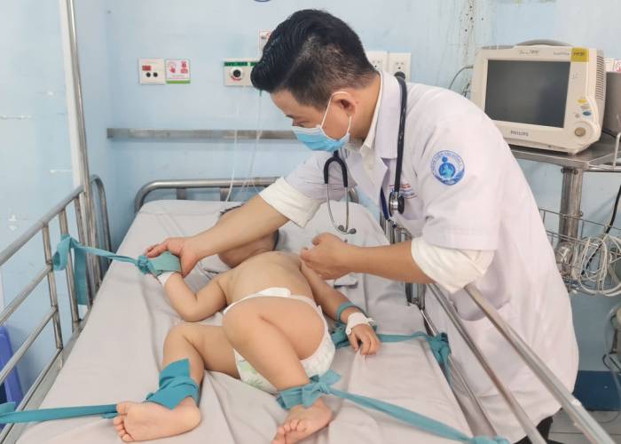 Trẻ tay chân miệng nặng điều trị tại bệnh viện Nhi đồng 1, được cố định tay chân vào giường để tránh kích thích. Ảnh: Lê Phương