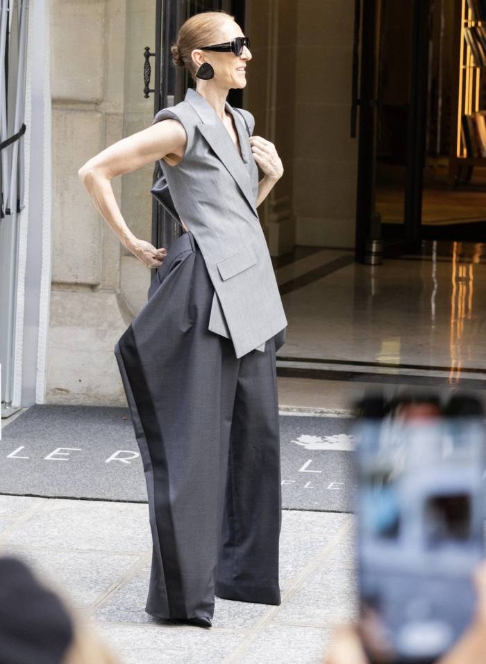 Celine Dion gây ấn tượng với phong cách độc lạ, vẫy tay chào người hâm mộ trước cửa khách sạn Le Royal Monceau. Ảnh: AFP