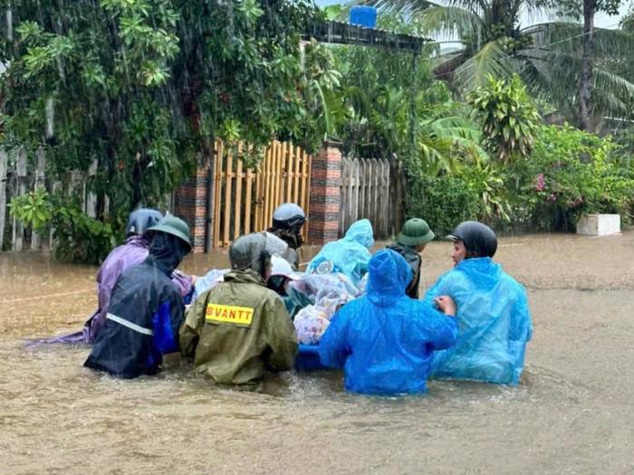 Người dân nhiều vùng ngập sâu ở xã Núi Thành sơ tán. Ảnh: Quang Cường