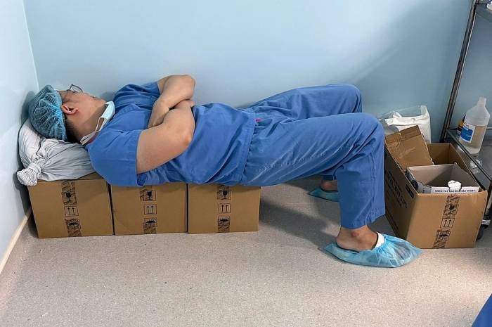Bác sĩ Phú ngả lưng chợp mắt ngay trong khu phòng mổ khi tranh thủ được chút thời gian sau những ca mổ kéo dài, được đồng nghiệp chụp hình lại. Ảnh: Bác sĩ cung cấp