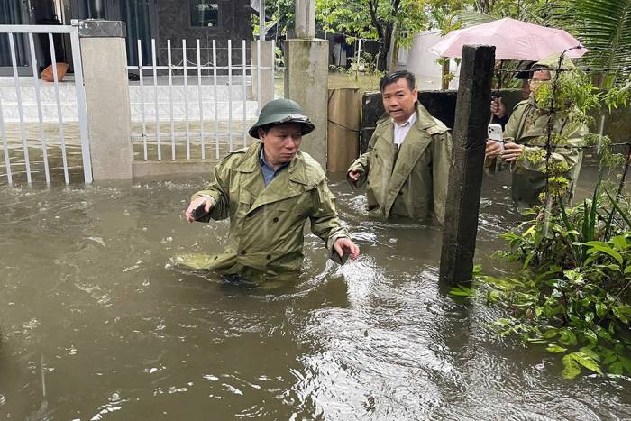 Bí thư Đảng ủy xã Núi Thành Nguyễn Như Công lội nước ngập gần 1m tiếp cận các khu vực dân cư. Ảnh: Lương Vũ