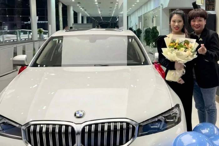 Bà Ma Yanli (ngoài cùng bên phải), đứng cạnh nhân viên Li Jie, khi đưa cô tới nhận quà là một chiếc ôtô BMW màu trắng hôm 24/9. Ảnh: SCMP