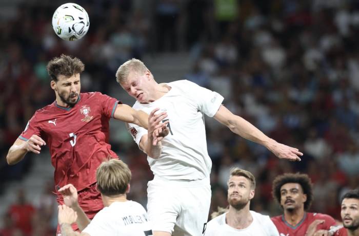 Erling Haaland (phải) tranh bóng bổng với Ruben Dias. Ảnh: Kapta+
