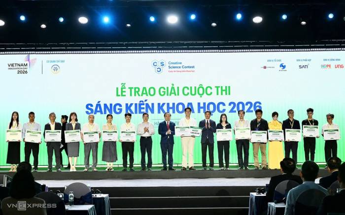 Bộ trưởng Khoa học và Công nghệ Vũ Hải Quân, ông Phạm Hiếu, Tổng biên tập báo VnExpress và ông Lưu Hoàng Long, Cục trưởng Sở hữu trí tuệ và các tác giả được giải Cuộc thi Sáng kiến Khoa học 2026. Ảnh: Giang Huy