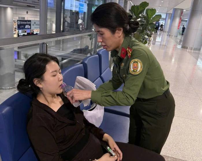 Cán bộ Công an cửa khẩu sân bay Tân Sơn Nhất hỗ trợ hành khách gặp vấn đề sức khỏe. Ảnh: Cục Quản lý xuất nhập cảnh