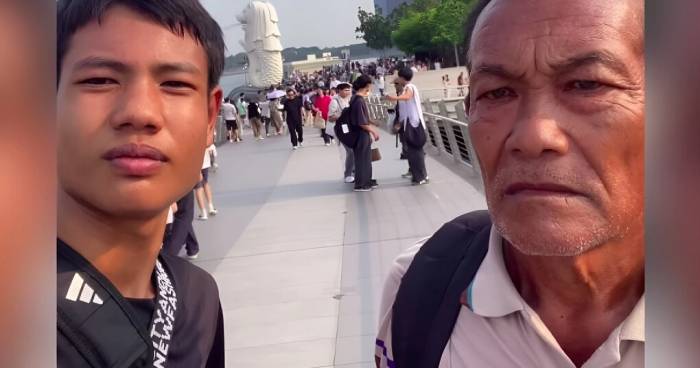 Queue và ông nội chụp ảnh trước tượng Sư tử biển nổi tiếng ở Công viên Merlion. Ảnh: AsiaOne