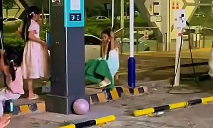 Hai bé gái dùng cáp sạc xe điện làm xích đu